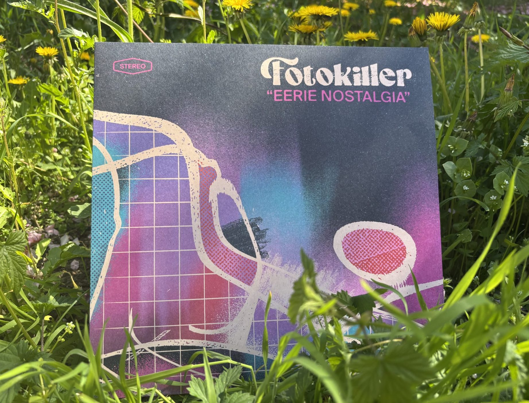 Fotokiller- Eerie Nostalgia 2025 - Titelbild, es ist ein abstraktes Design in lila, rosa, türkis und schwarz zu sehen. Oben steht in heller Schrift Fotokiller, darunter in pink Eerie Nostalgia