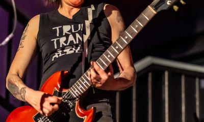 Patsy Stone spielt voll Eifer mit einer roten Gitarre auf einer Bühne